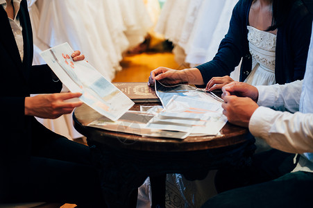 婚礼策划师与新娘新郎讨论礼服设计图片
