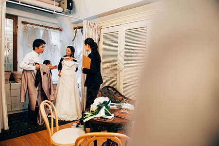 挑选婚纱的3人与婚礼策划师高清图片