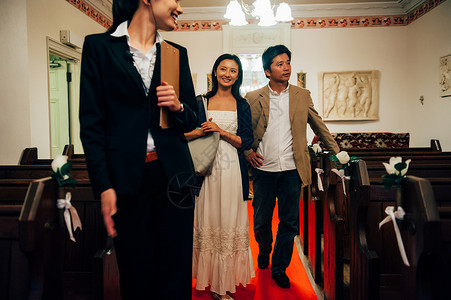 在礼堂婚礼策划师与新郎新娘讨论婚礼细节图片