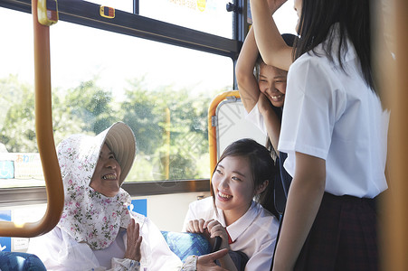 一群学生和坐公交车的奶奶交谈快乐高清图片素材