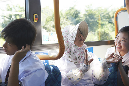 坐公交车和学生交谈的奶奶公车高清图片素材