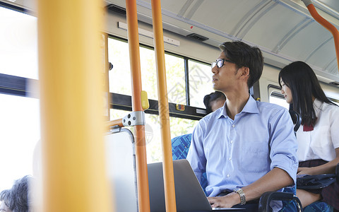 坐公交车使用电脑的男性赶紧高清图片素材
