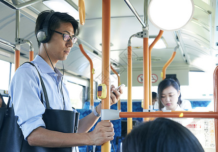 公交车上戴耳机的男性车子高清图片素材