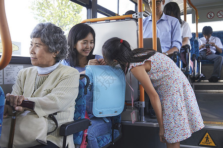 妈妈和女儿一起乘坐公交车书包高清图片素材