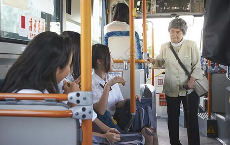 公交车上的老人和高中女生交谈高清图片素材