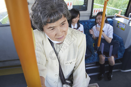 公交车上的未给老人让座的高中生公交车通勤高清图片素材