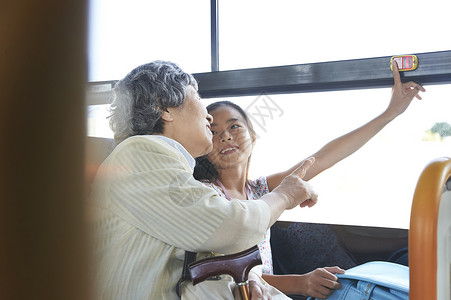 公交车内的奶奶和孙女在开心聊天图片