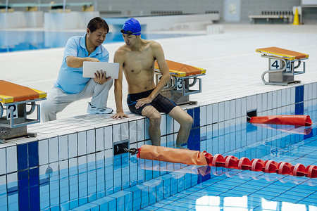 指导训练的游泳运动员和教练领班高清图片素材