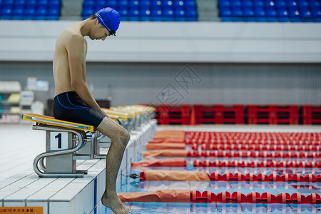 泳池边沉思的游泳运动员图片