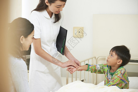护士为住院的男童检查身体窗帘高清图片素材