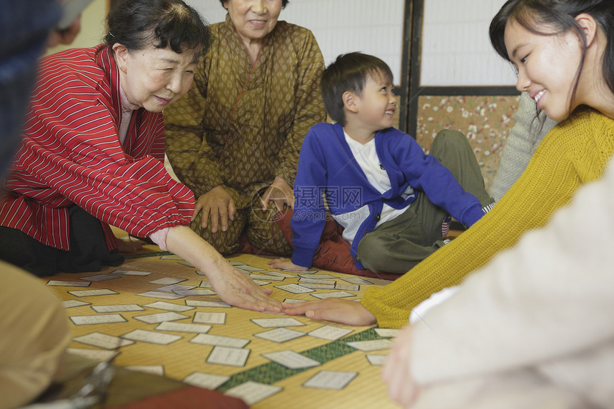 陪孩子玩纸牌游戏的一家人图片