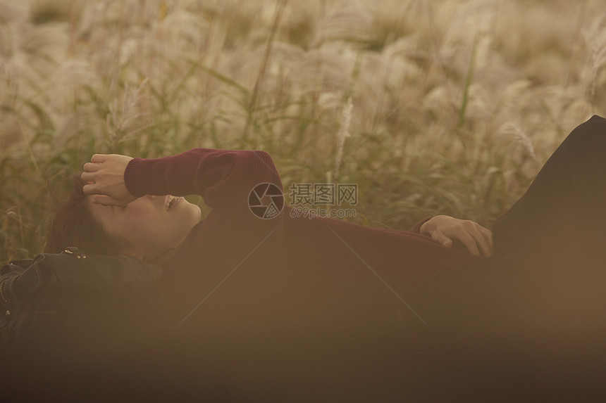 女人躺在野外草地上休息图片
