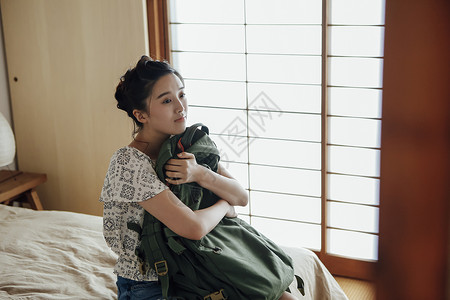 假期出游的女背包客在旅店的形象旅游高清图片素材