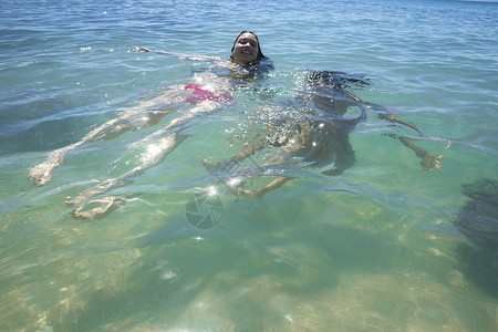 大海里仰泳的年轻女孩图片