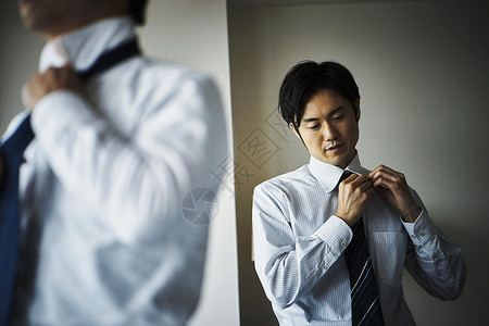 整理领带的商务男士打扮高清图片素材