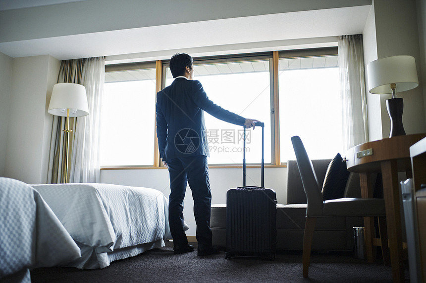商务男子拎着行李箱入住酒店图片