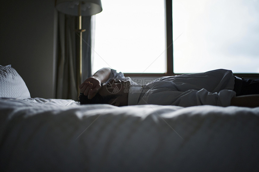 精疲力竭的白领躺在酒店床上