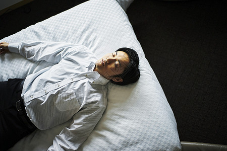 早晨在酒店床上休息的商务男子休假高清图片素材