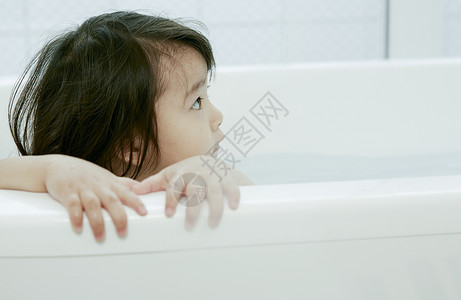 小女孩在浴缸里洗澡高兴高清图片素材