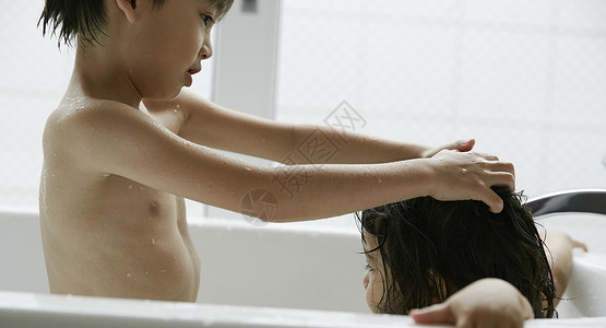 两个小朋友在浴缸里洗澡乐趣高清图片素材