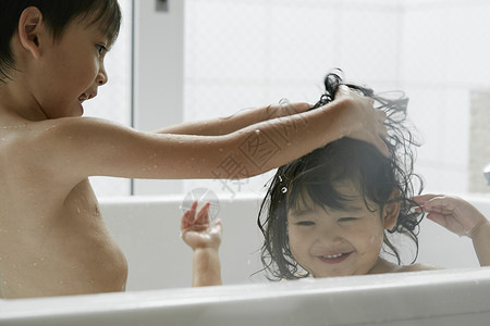 两个小朋友在浴缸里洗澡家人高清图片素材