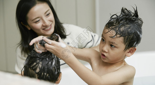 妈妈给孩子们浴缸里洗澡男孩高清图片素材