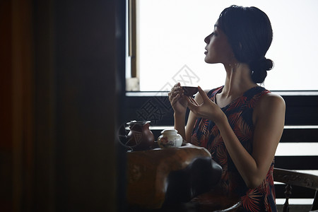 女游客端着茶杯看窗外日本人高清图片素材