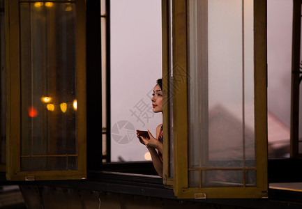 女人在茶馆窗台边品茶看风景图片