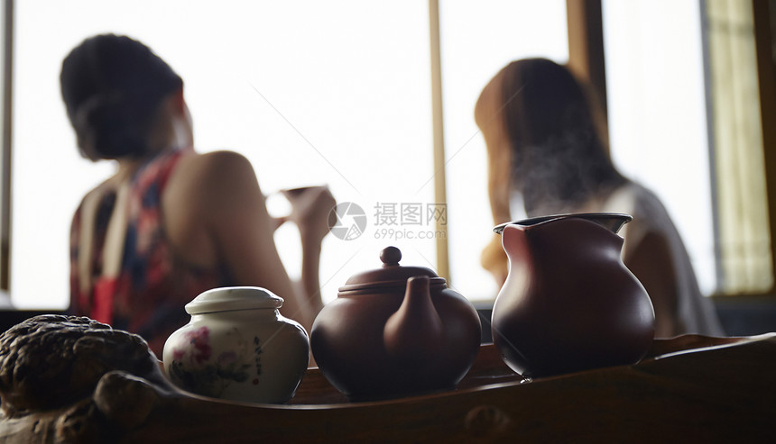 女人在茶馆窗台边品茶看窗外图片