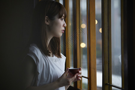 女人在茶馆窗台边品茶看窗外晴朗高清图片素材
