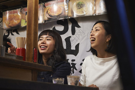 喝清酒吃烧烤的女游客在大笑福冈旅游业高清图片素材