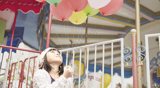 小女孩在游乐园手拿气球图片