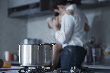 厨房里拥抱接吻的情侣图片