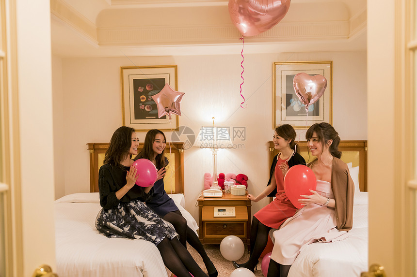 朋友聚会女人们在卧室拿着气球说笑图片