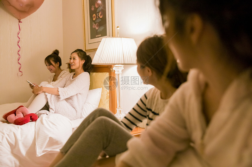 朋友聚会穿着睡衣的女人在卧室聊天图片