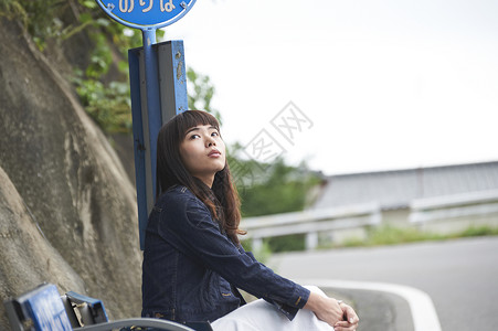 旅游少女坐在路拍下仰望天空图片