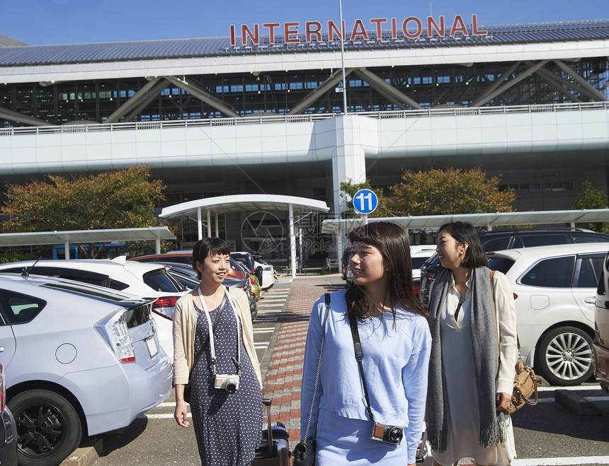 在机场停车场拿着行李走的女人们图片