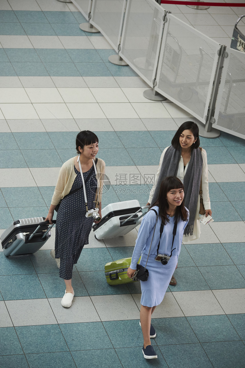 在机场停车场拿着行李走的女人们图片