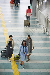 女生拖着行李走在机场图片