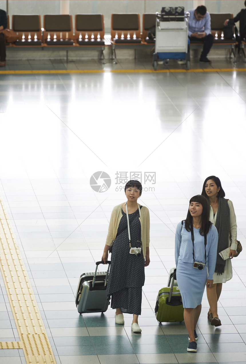 在机场航站楼拖着行李赶飞机的女性图片