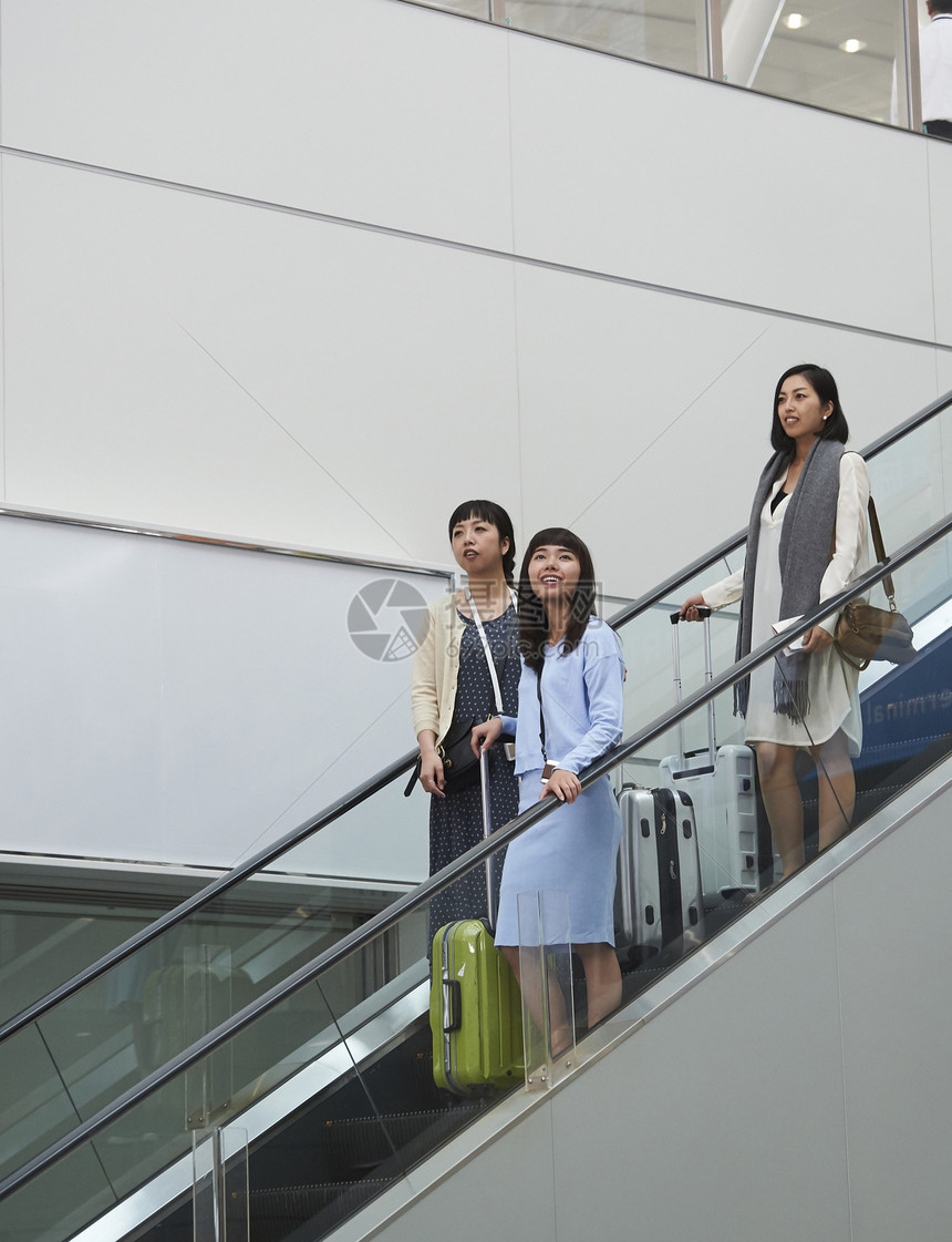 在航空站楼梯上带着行李的女人们图片
