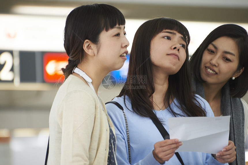 在航空站带着行李的女人们在看说明图片