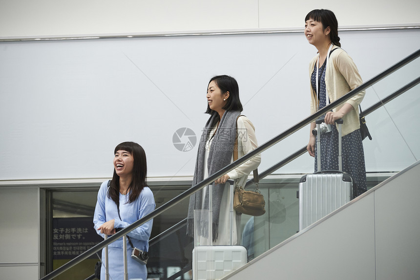 在航空站楼梯上带着行李的女人们图片