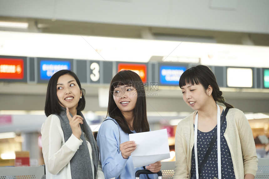 在航空站带着行李的女人们在看说明图片