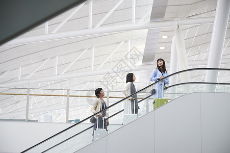 带着行李站在航空站扶梯上的女人们图片