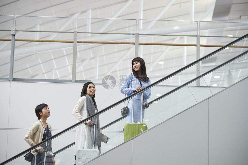 带着行李站在航空站扶梯上的女人们图片