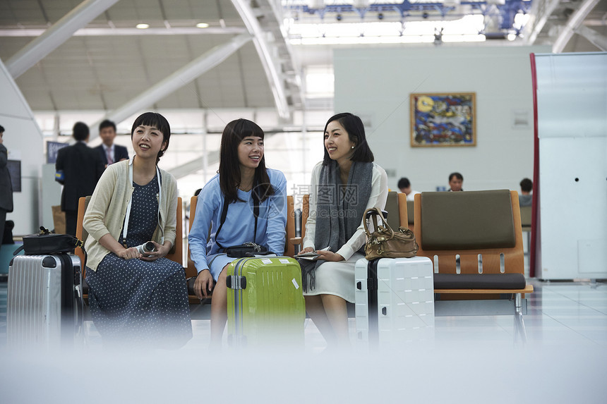 坐在航空站候车室椅子上的女人们图片