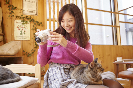 猫咪陪着女性在咖啡店工作玩高清图片素材