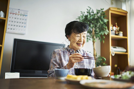 坐在家里吃饭的老妇人图片