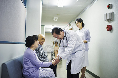 医院走廊上医护人员和老年病人交谈图片